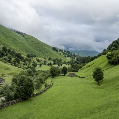 Meadows and rustic stone cabins in beautiful green valley